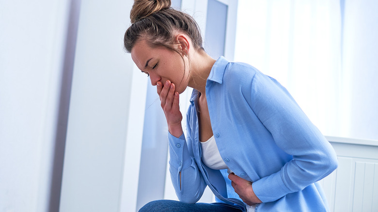 Woman covering her mouth to prevent vomiting