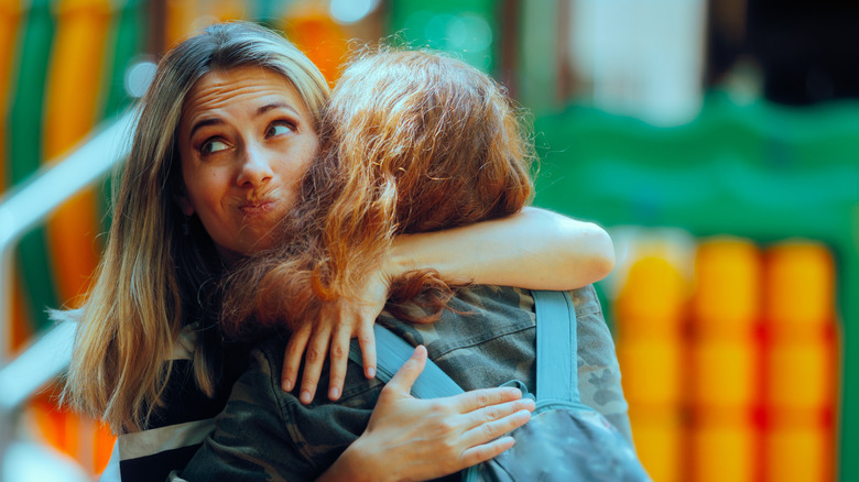 Woman Hugs Fake Friend Making Faces Behind her Back