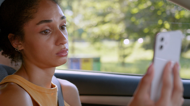 Annoyed looking woman looking at her phone