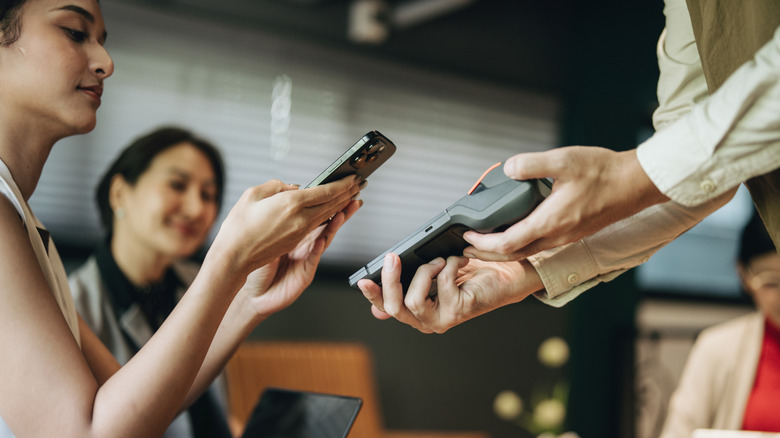 Woman paying in a restaurant with credit card