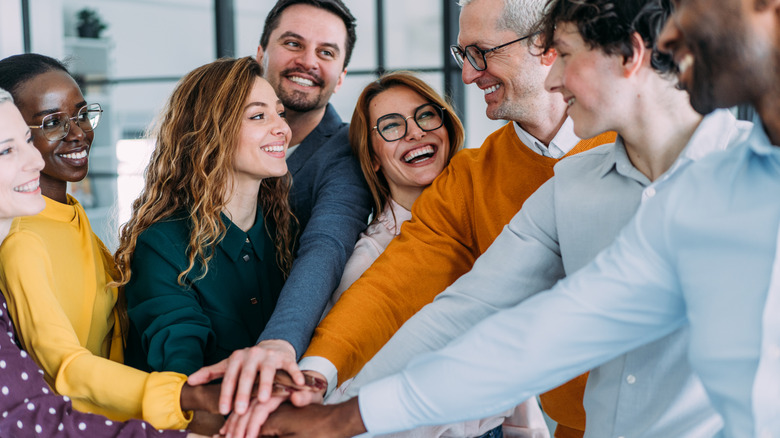 A group of people putting their hands together