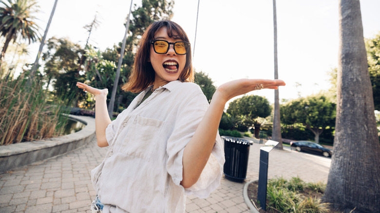 An extroverted woman is dancing outdoors