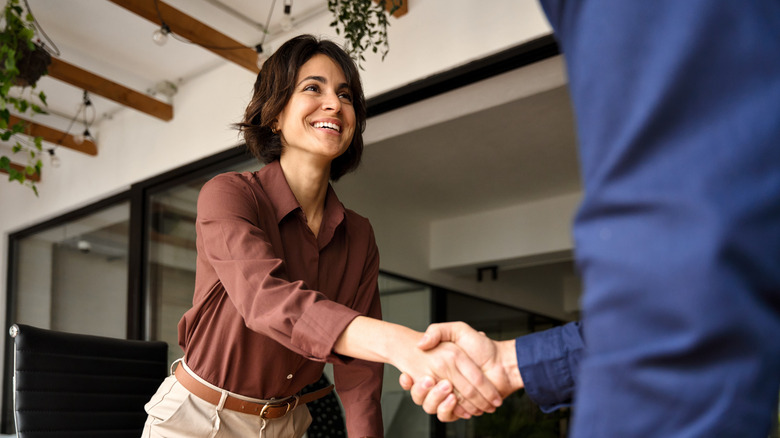 A woman and a man are shaking hands