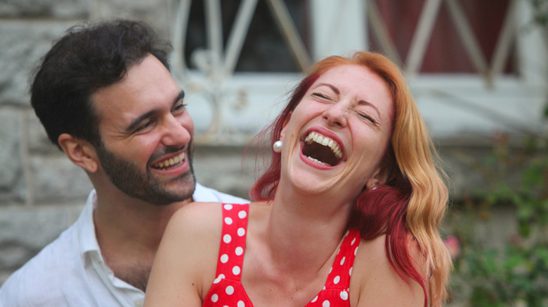 A man and a woman are laughing together