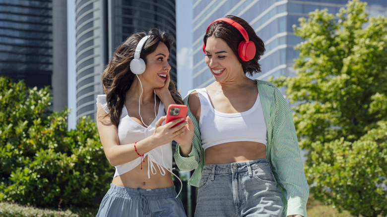 Two friends are enjoying music with headphones