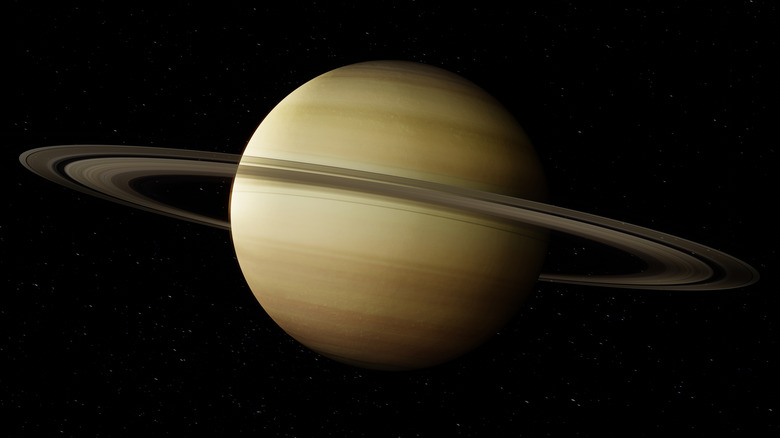 Planet Saturn with its rings is seen against a dark backdrop