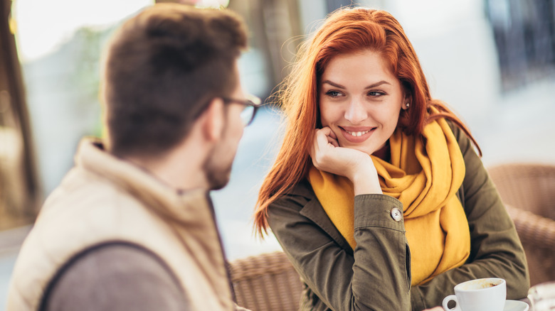 Couple looking happy and talking while having coffee