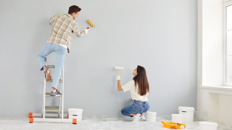 Happy couple painting a wall