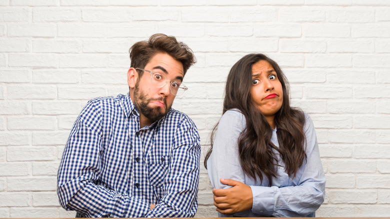 A man and a woman are looking anxious