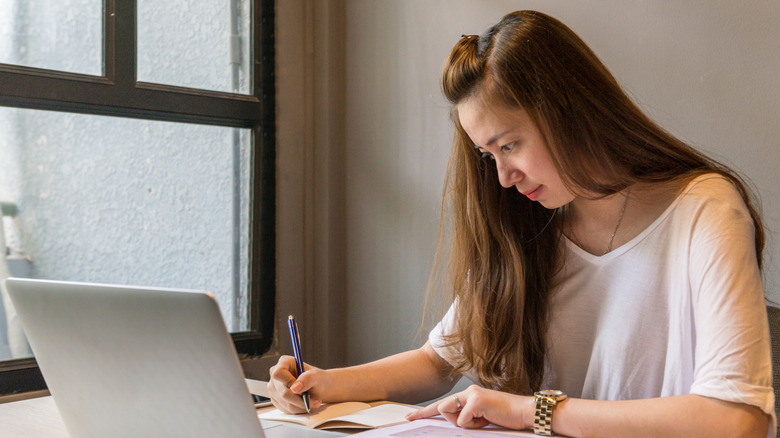 Woman writing with intense expression