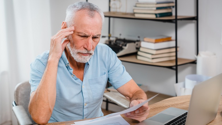 Man looking at documents with confused expression