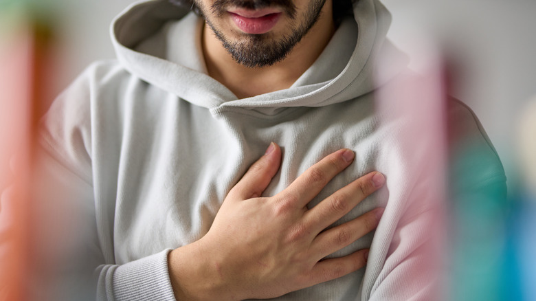 Man with hand over chest in pain