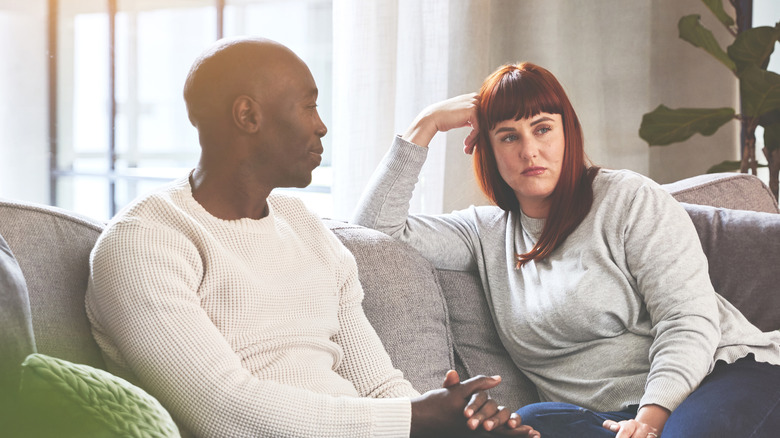 Couple sitting on the sofa having a serious discussion