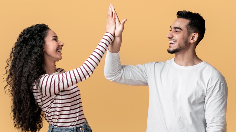 Young couple celebrating with a high five