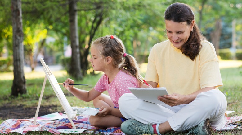 Woman and girl painting and drawing in a park