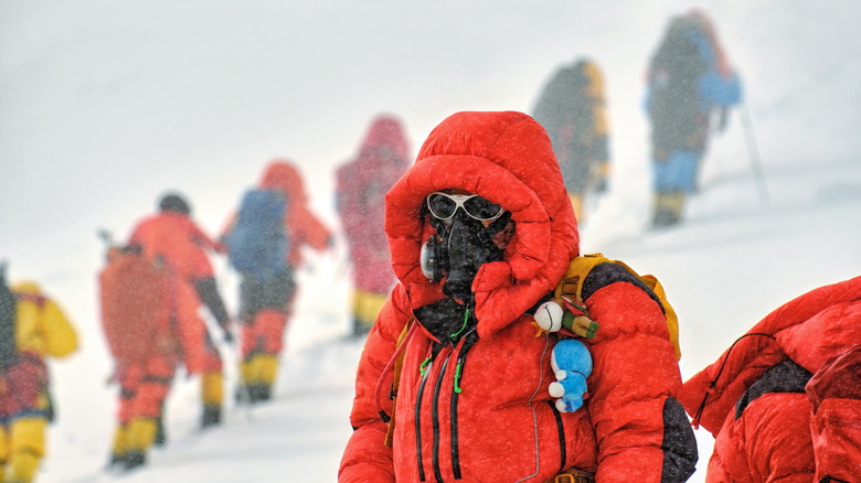 Everest Mountaineer in dense jacket with oxygen mask on and sunglasses