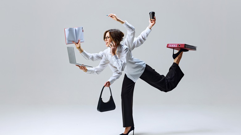 Humorous image of business woman multi-tasking, with 6 arms carrying out different tasks