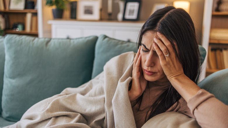 Woman lying on sofa with a headache