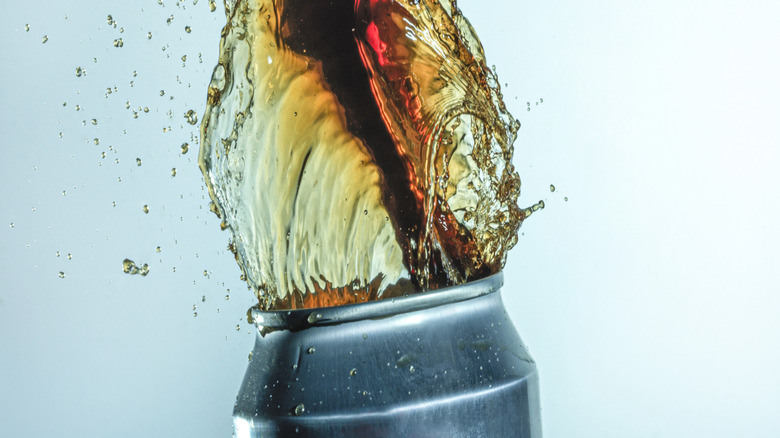 Soda exploding from the top of an opened can