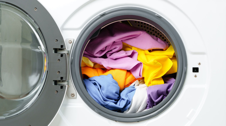 Close-up of colorful laundry in a white washing machine with the door open
