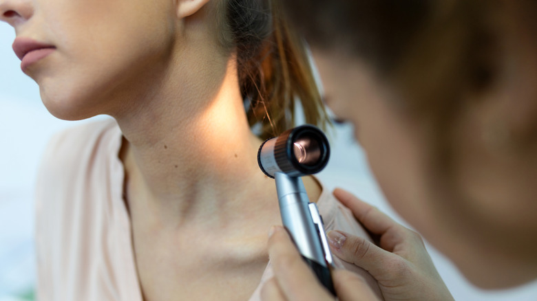 Dermatologist using a dermatoscope during skin cancer screening