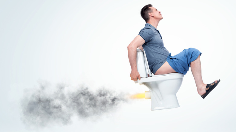 Man on toilet that's taking off into the air in a representation of explosive diarrhea