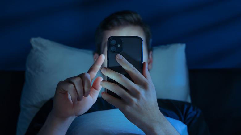 man in bed at night on his smartphone