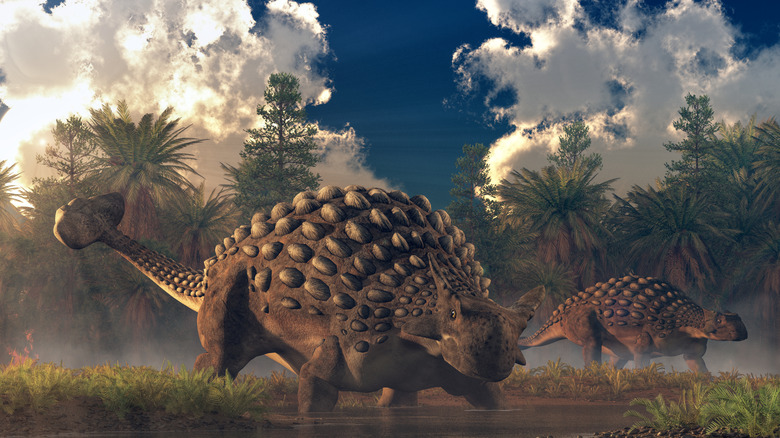 A pair of ankylosauruses graze in a watery lowland