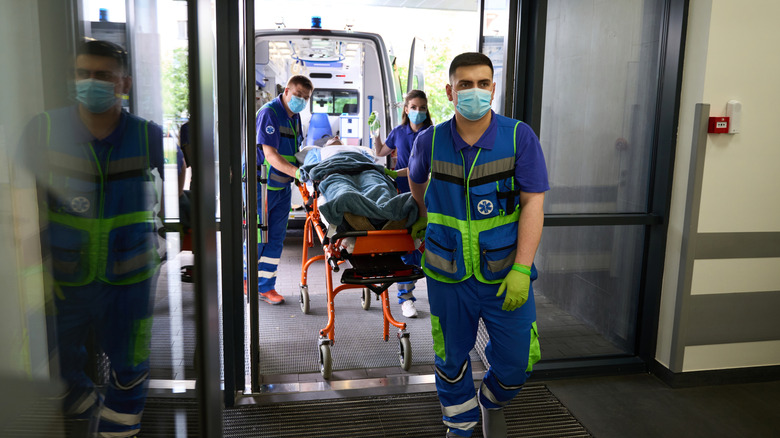 Paramedic and nurse admitting a critical patient into emergency room