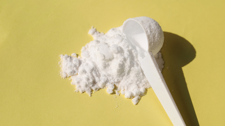A scoop with powder spilling out.