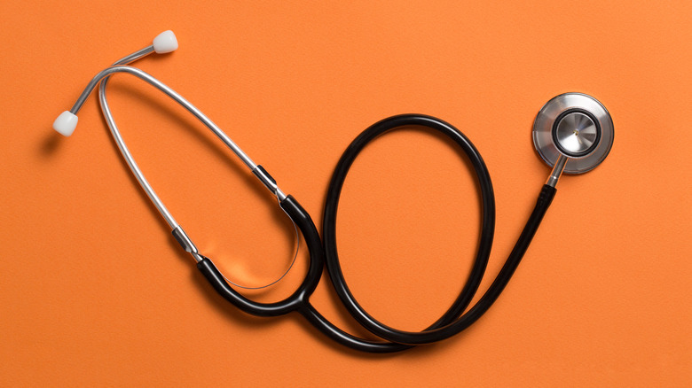 A stethoscope on an orange background.