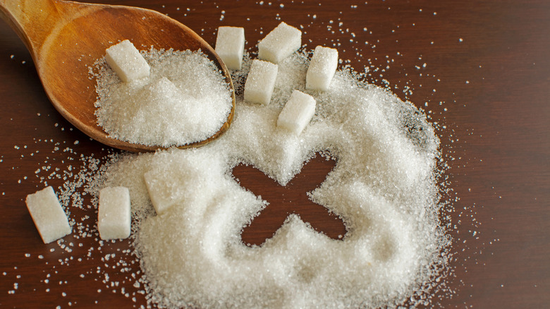 Spoon next to white sugar on table