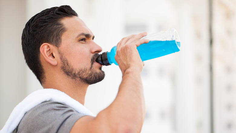 Man drinking sports drink after exercising