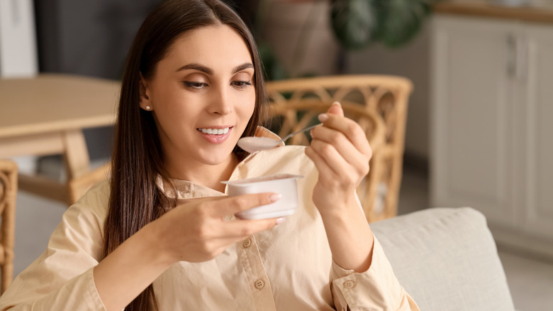 Woman eating yogurt from a cup