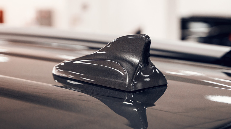 Close-up of shark fin antenna on the roof of a dark gray car