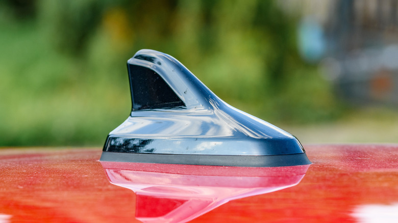 Close-up of a black shark fin antenna on a red car