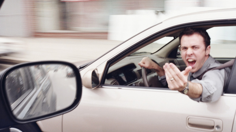 Man yelling at a passing car, road rage