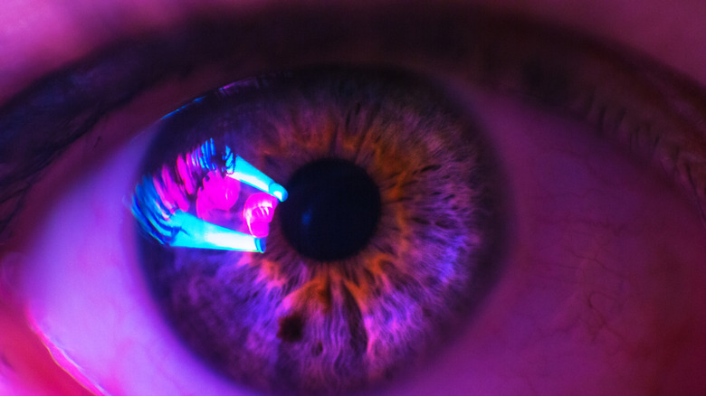 Female human eye with neon colors reflected in it