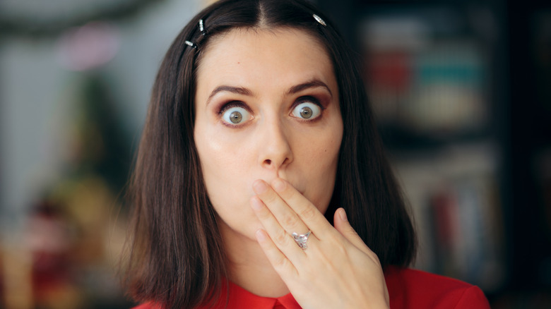 Woman holding a hand over her mouth