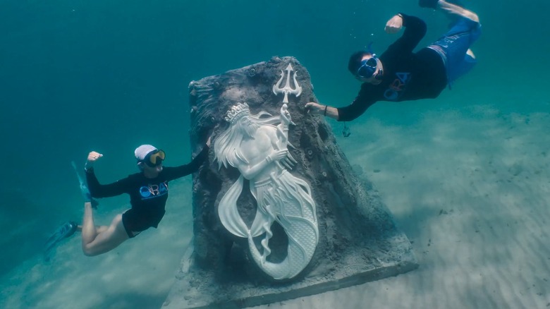 ORAI team poses with underwater Guardians of the Reef installation