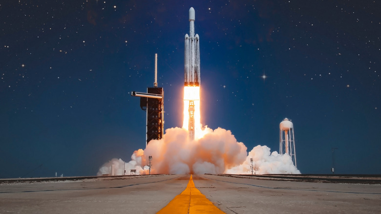 A SpaceX Falcon Heavy rocket carrying NASAs Europa Clipper spacecraft takes off leaving a cloud of smoke below
