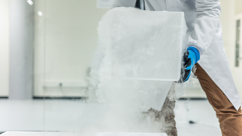 A scientist handling a tub of dry ice