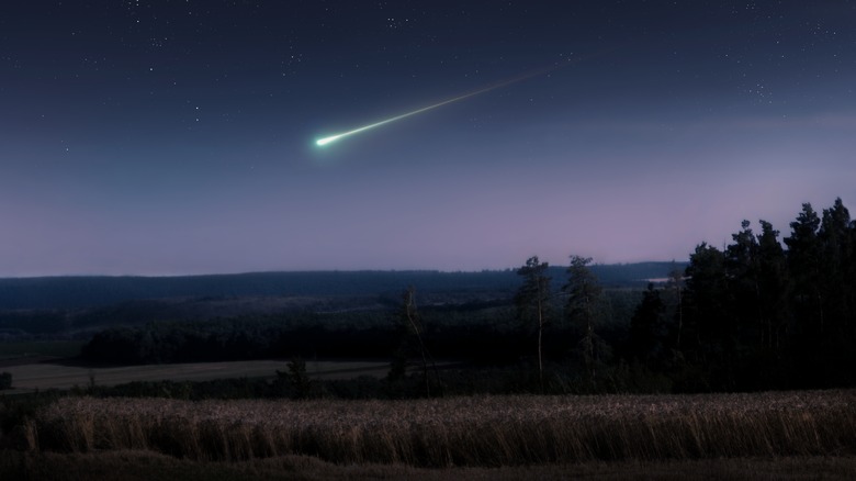 bright meteor over rural landscape