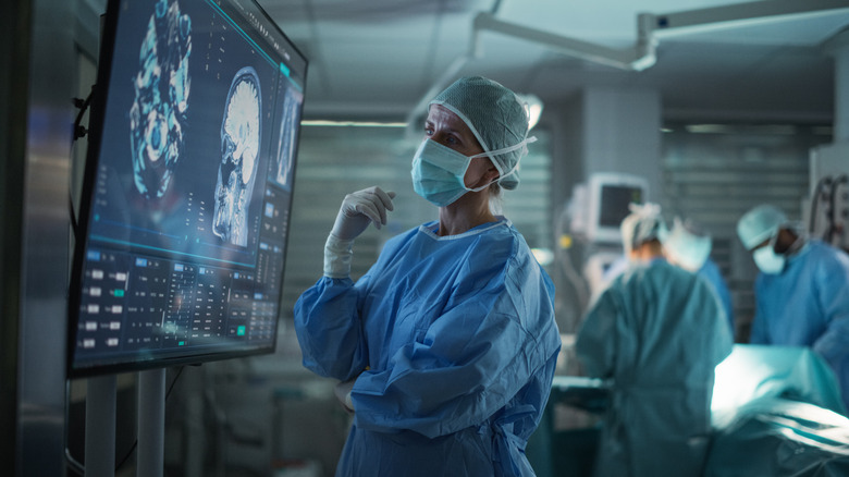 Female surgeon looking at image of patient's head