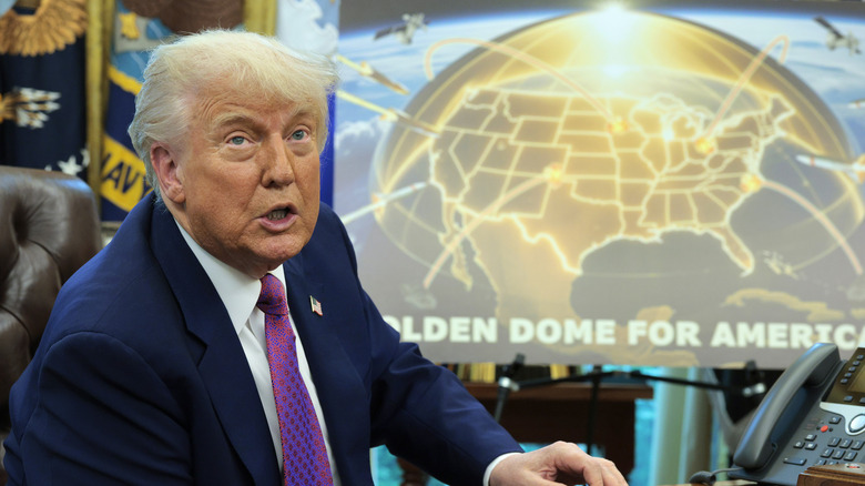 President Donald Trump speaking from the Oval Office with a graphic of the proposed "Golden Dome" system behind him