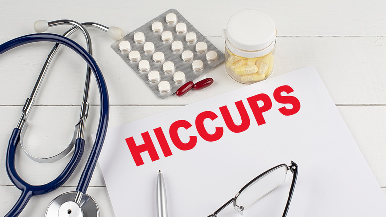 Medical equipment sits on a desk with a piece of paper that says "Hiccups"