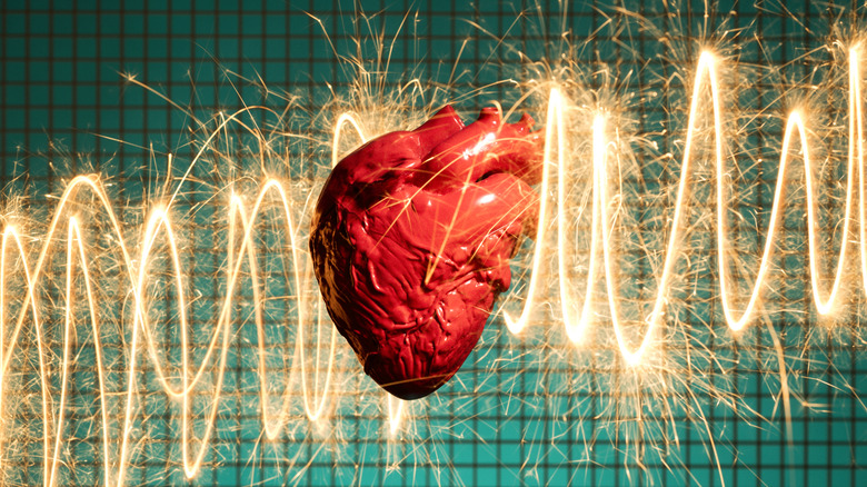 A model of a human heart is seen surrounded by sparks