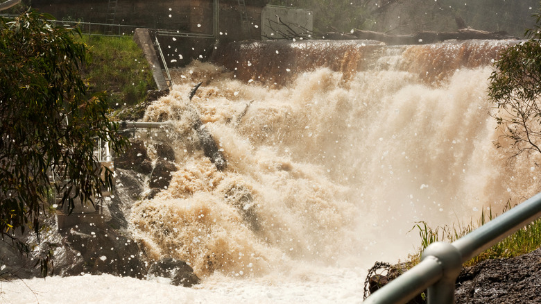 Flood waters flowing over a dam