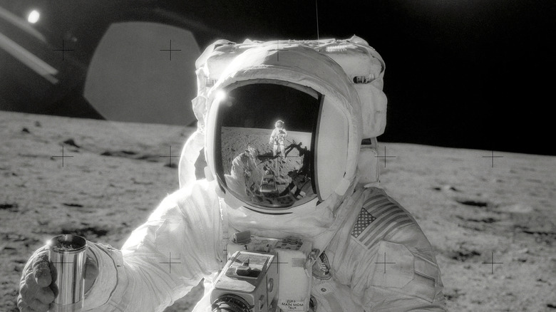 Alan Bean wearing spacesuit with another astronaut reflecting from his visor