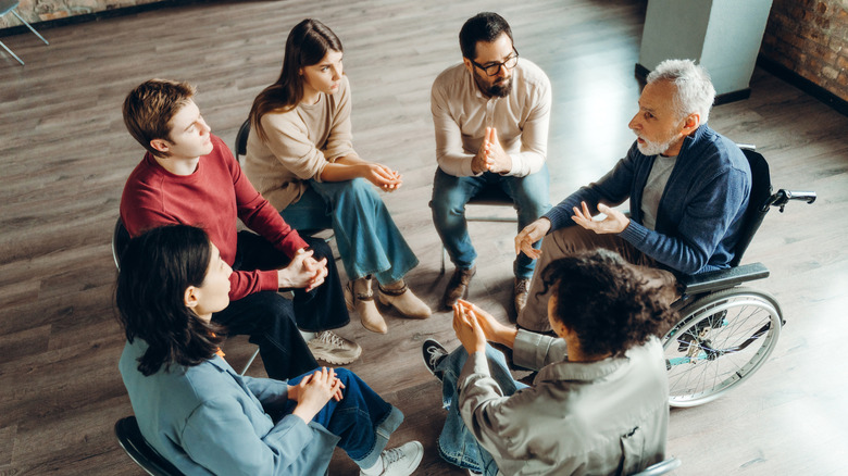 A group of people sitting in a circle talking